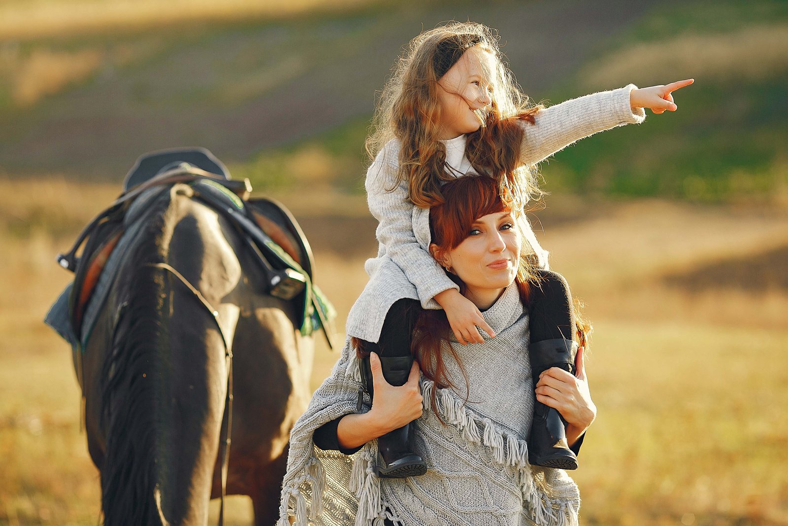 mother and daughter demonstrating secure attachment with horse in background